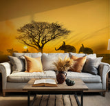 Dramatic golden-hour landscape with elephants and tree silhouettes