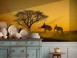 Elephants at sunset with a golden sky and tree silhouette, perfect for serene wall decor